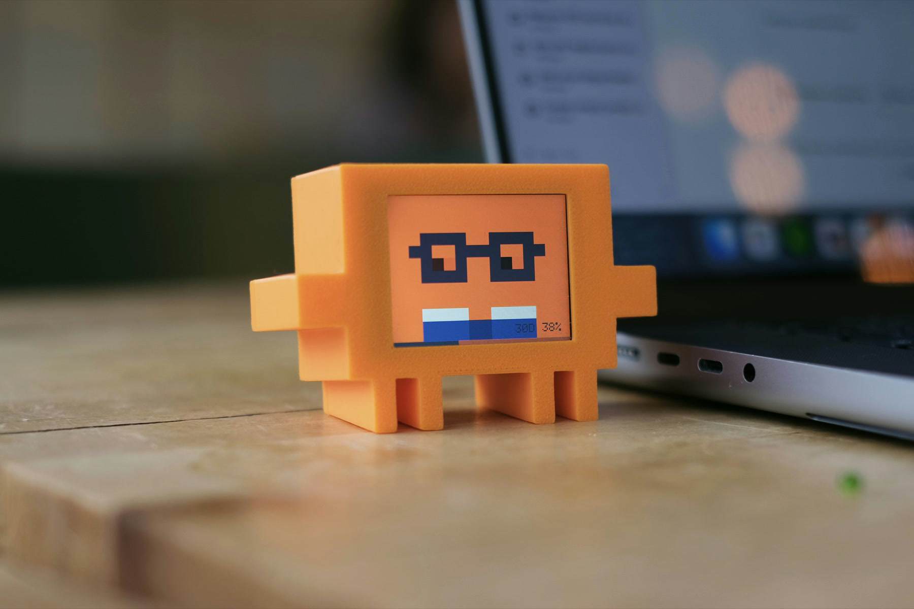 Vibe Buddy beside a laptop on a wooden coffee shop table