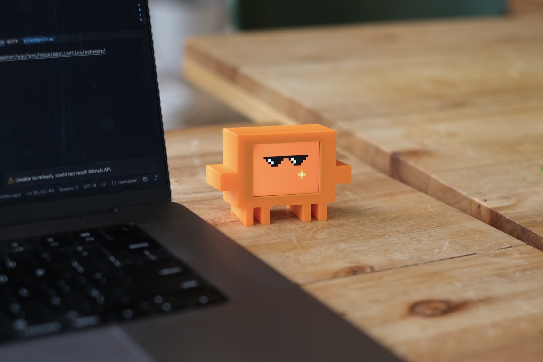Vibe Buddy wearing pixel sunglasses beside a laptop